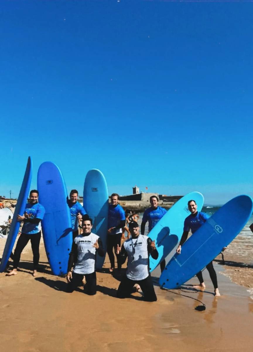 Turma de surf com as pranchas na areia